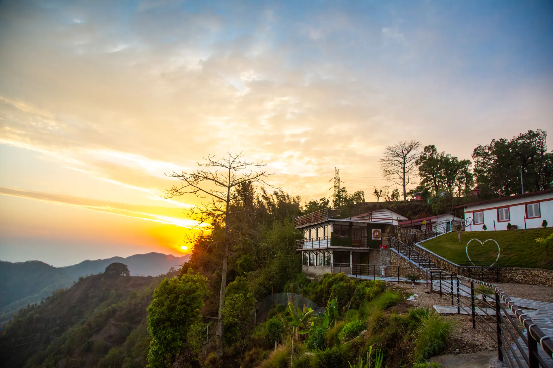 Hillside resort buildings overlooking the Sindhuli valley at sunset